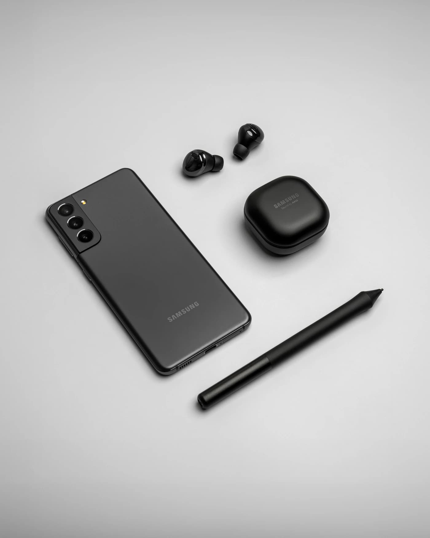 Samsung phone with wireless earbuds on a neutral surface — illustrative smartphone photograph