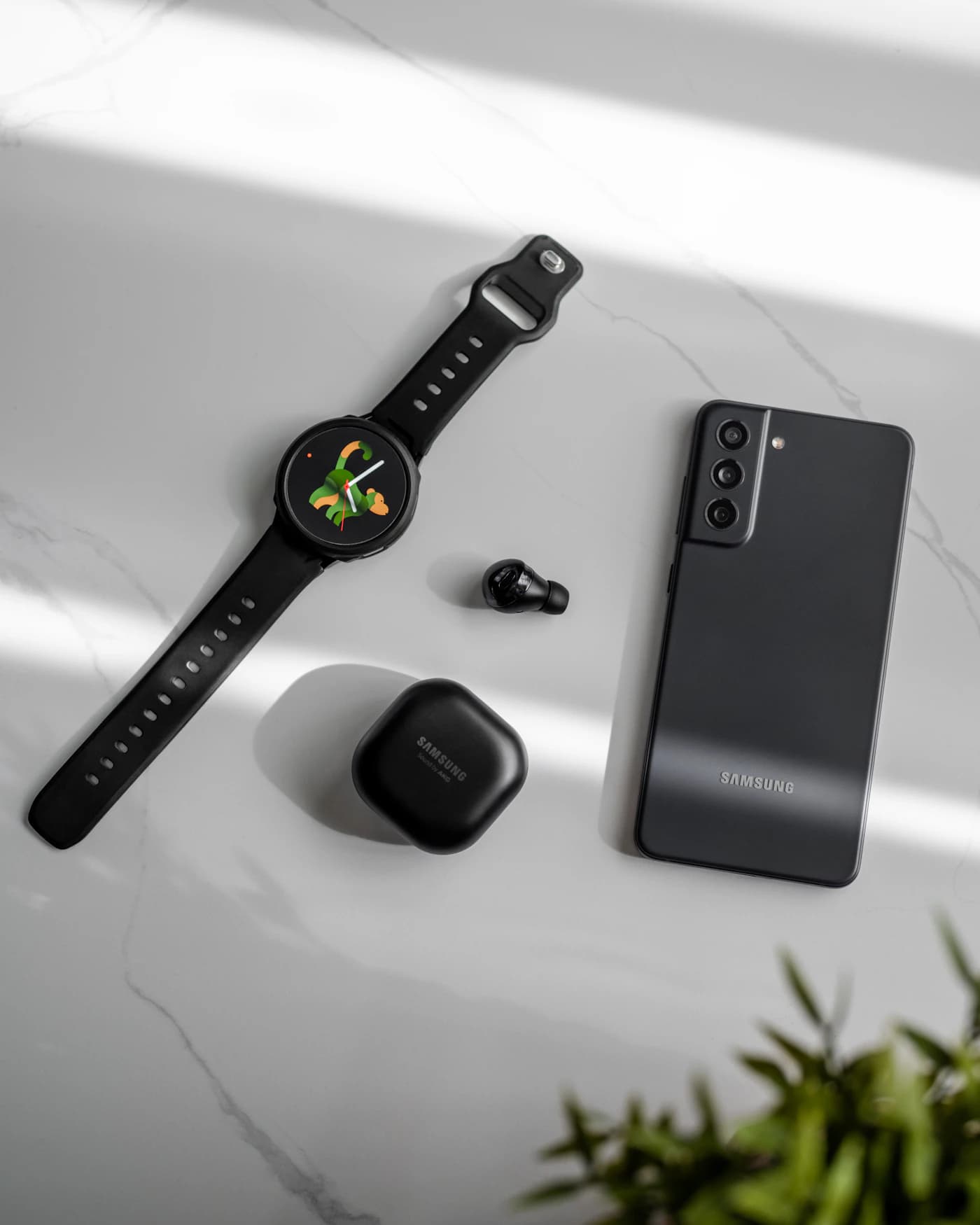 Smartwatch and wireless earbuds on a marble surface — illustrative wearable photograph