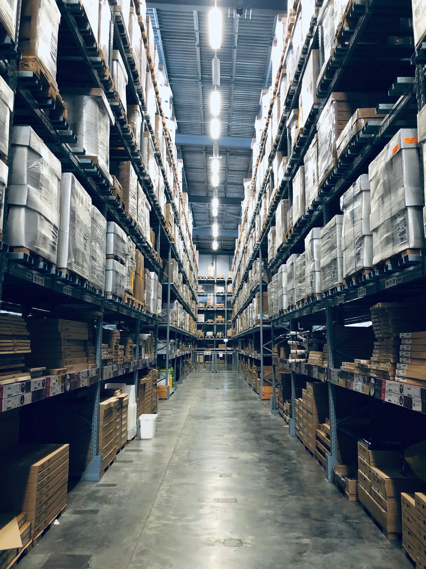 Tall warehouse shelving creates a clear aisle through stored cartons